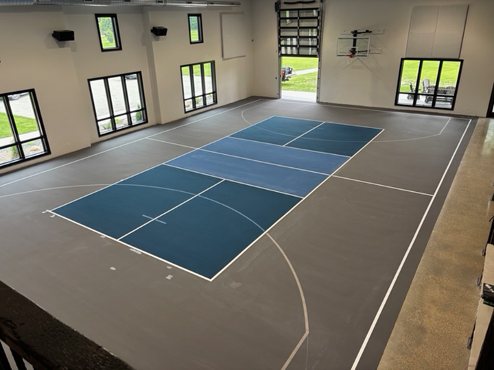 a resurfaced indoor pickle ball court using blue and gray colors