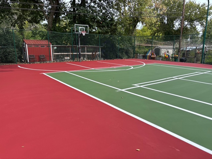 a resurfaced red and green combination outdoor basketball and tennis court